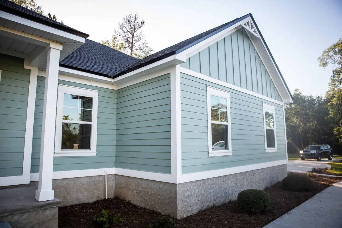 Home with board and batten gables, lap siding and a stone foundation