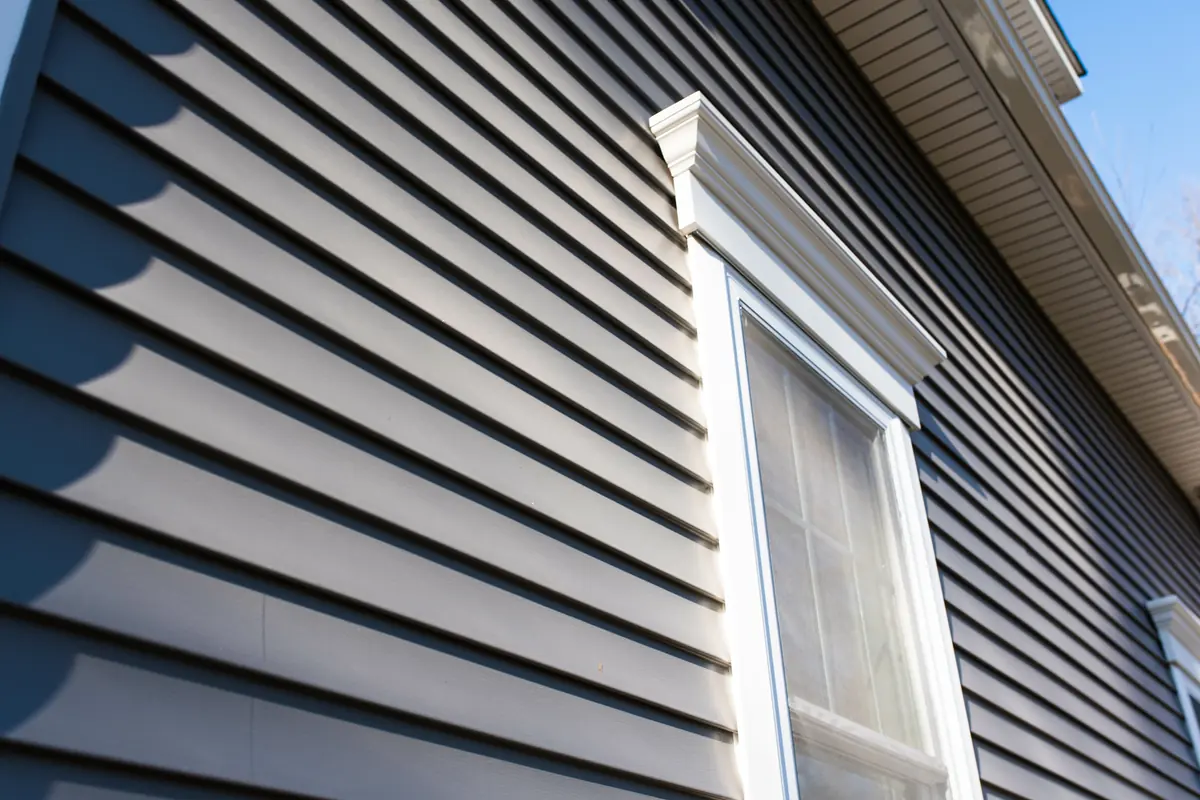 Close-up of dark lap siding with white window trim