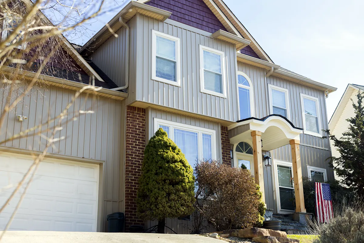 Close-up of new vertical siding, trim and arched entry