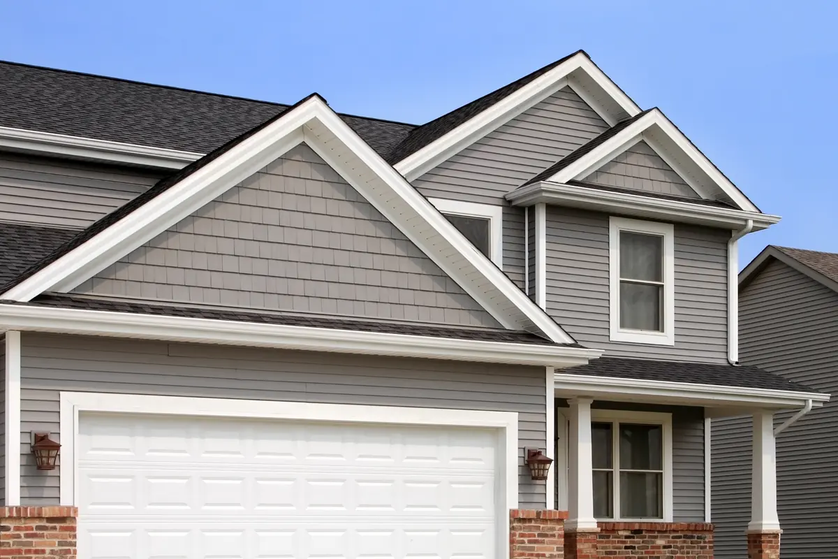 Two-story home with gray siding and a white garage door