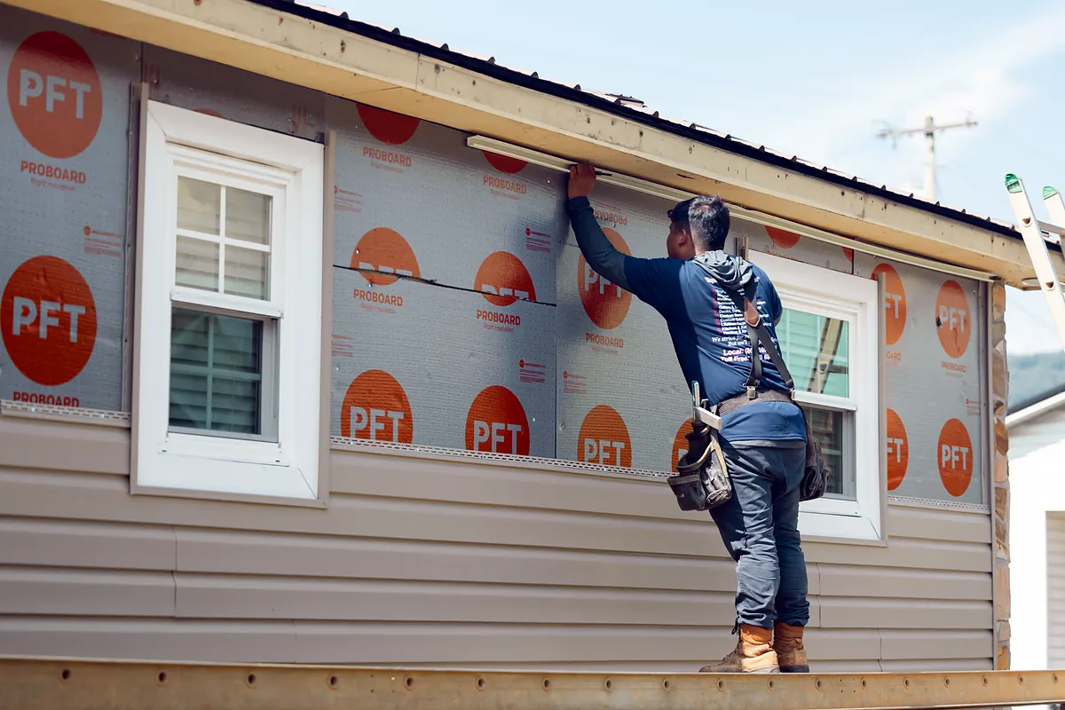 Installer wrapping a wall in house wrap before new siding