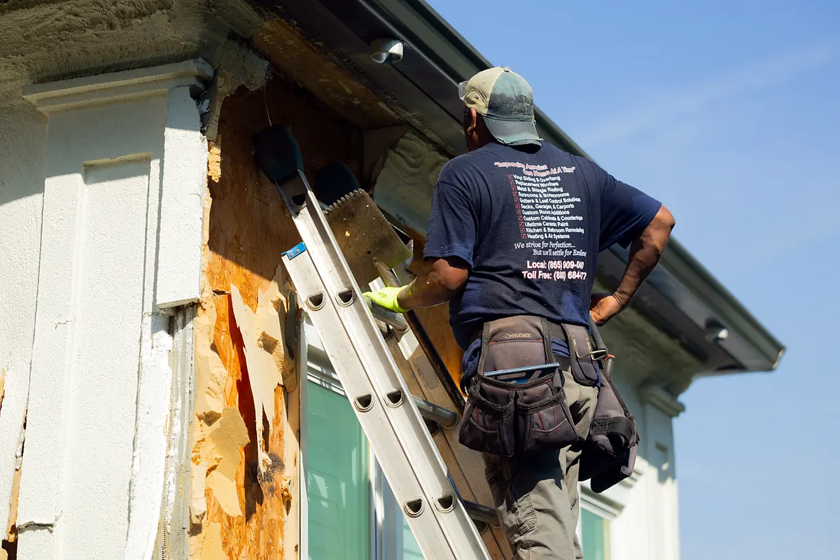 Siding crew tearing off old siding and finding water damage
